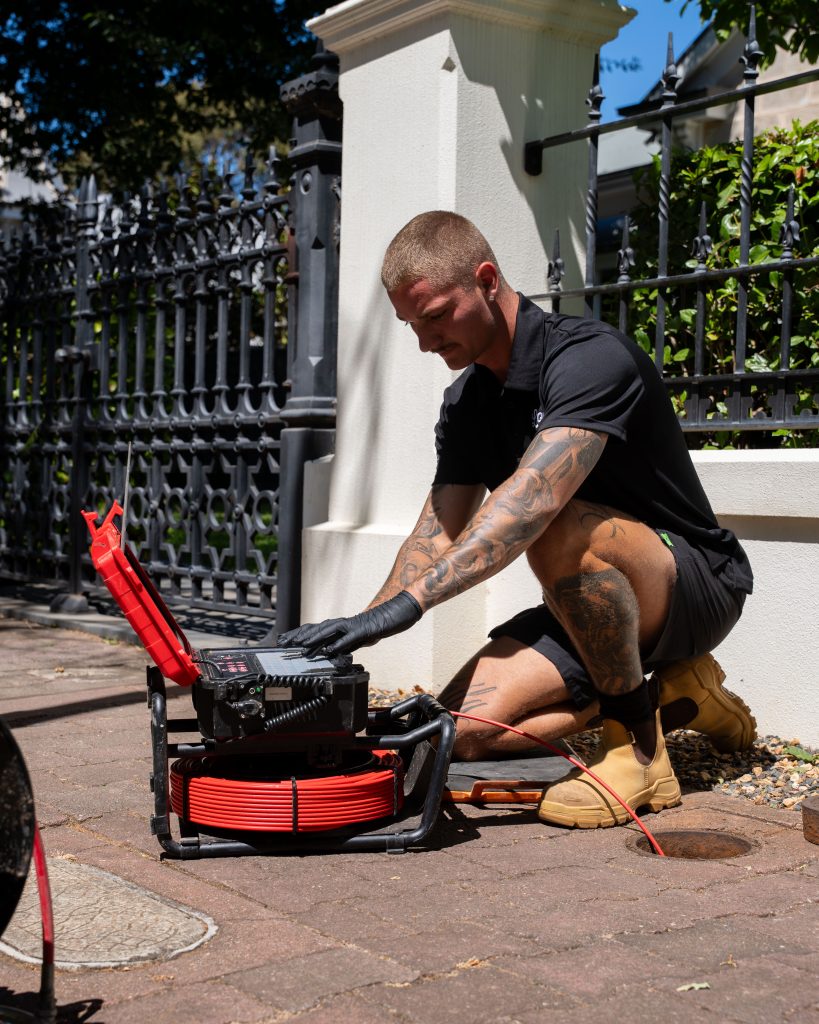 Plumber with CCTV drain camera: Loyal Plumbing plumber performing CCTV drain camera inspection for blocked drain in Craigmore SA
